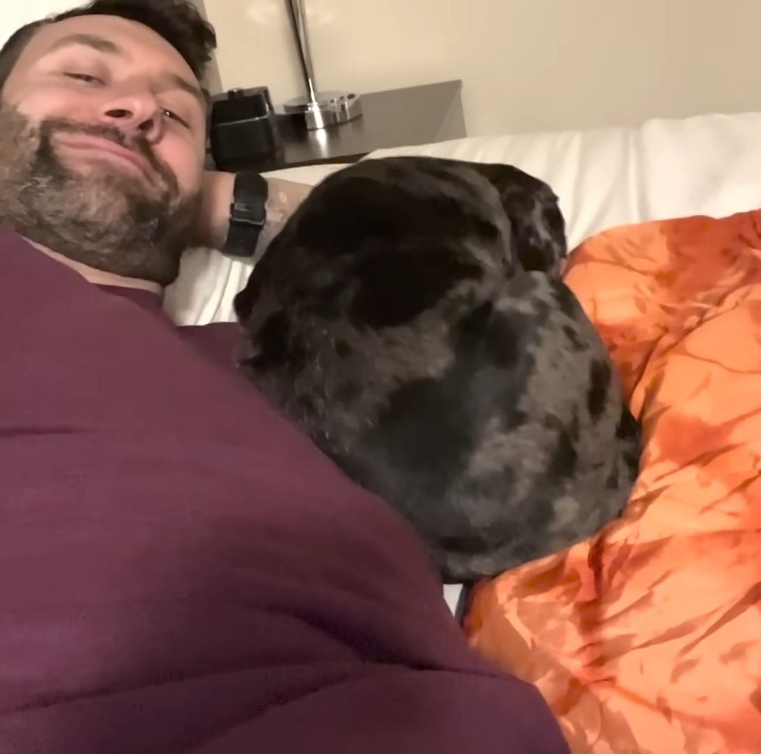 puppy sleeping next to a man
