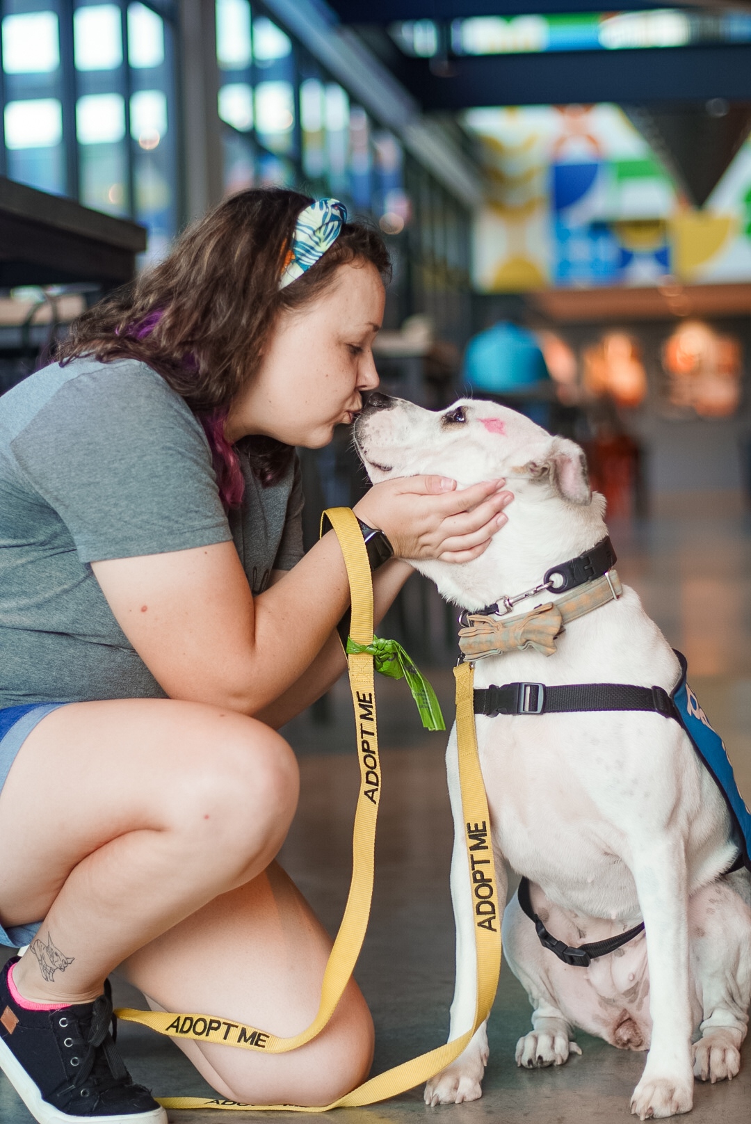 woman kissing white dog