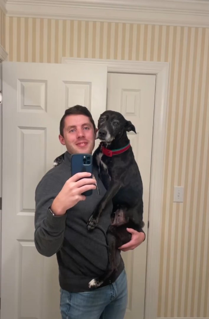 guy holding a black dog