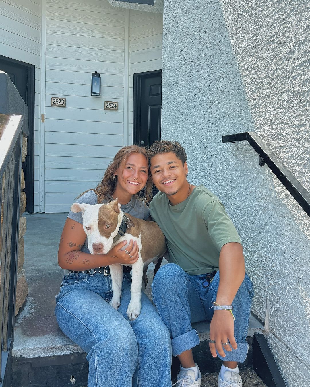 happy young couple posing with their adopted dog