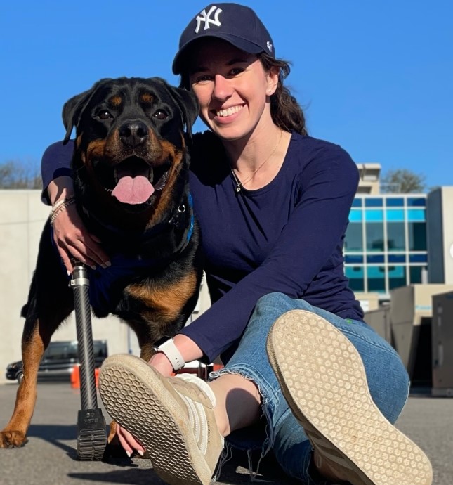 smiling girl with a dog that has a prosthesis