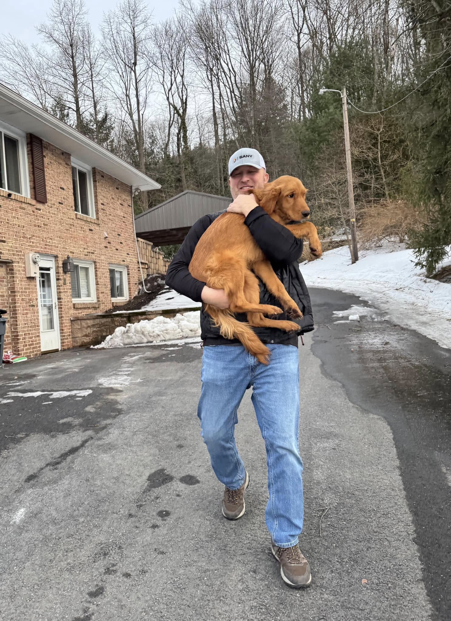 man holding a brown dog