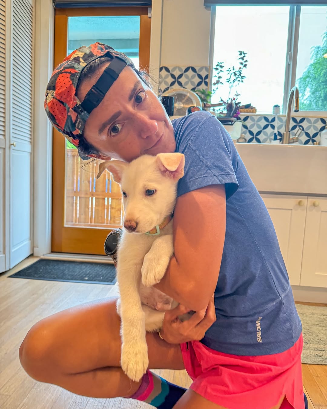 Woman with cap holding a dog