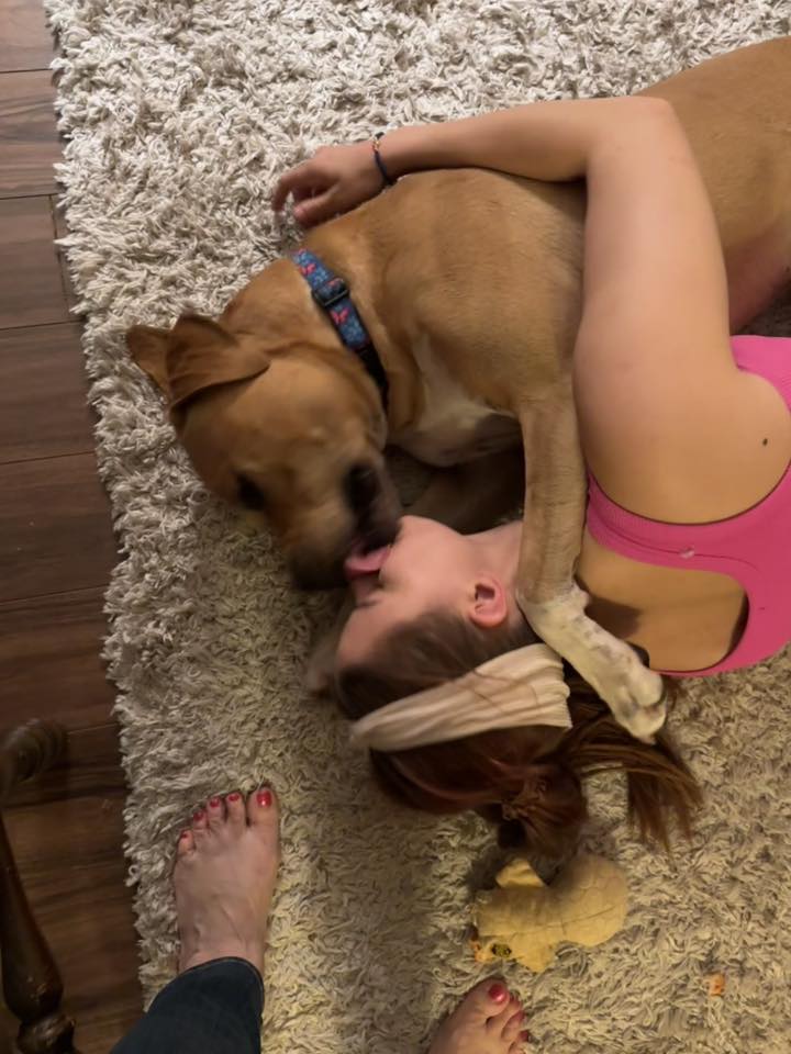 woman kissing a dog