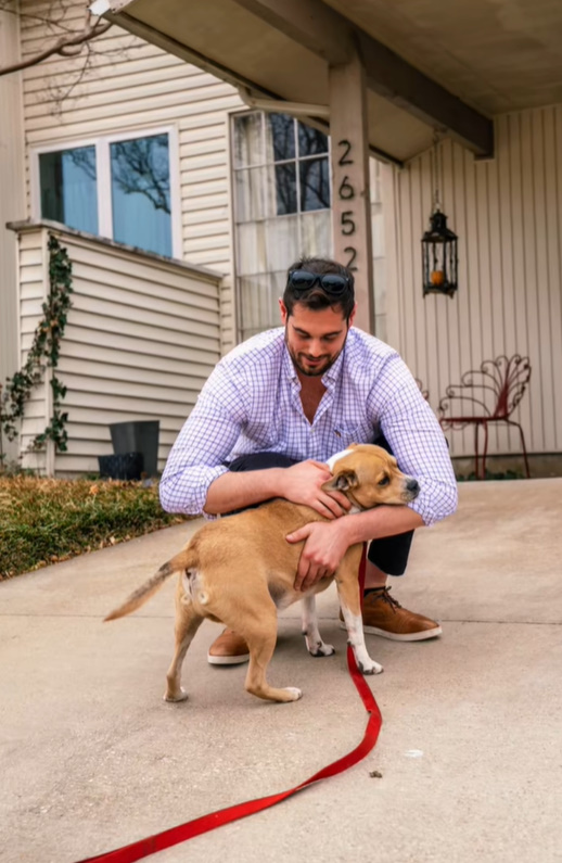 man hugging a dog