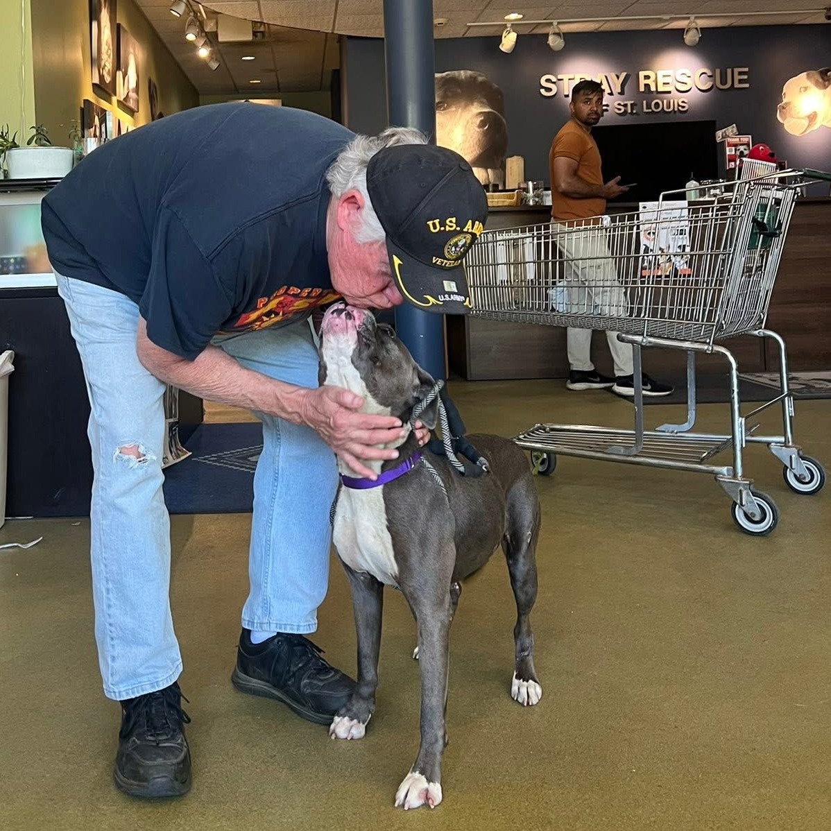 old man kissing a dog