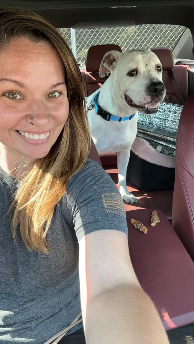woman and white dog in car