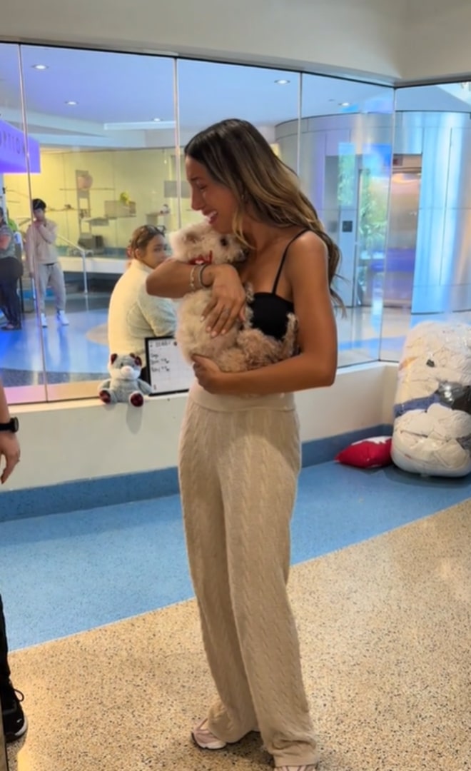 woman holding a white dog