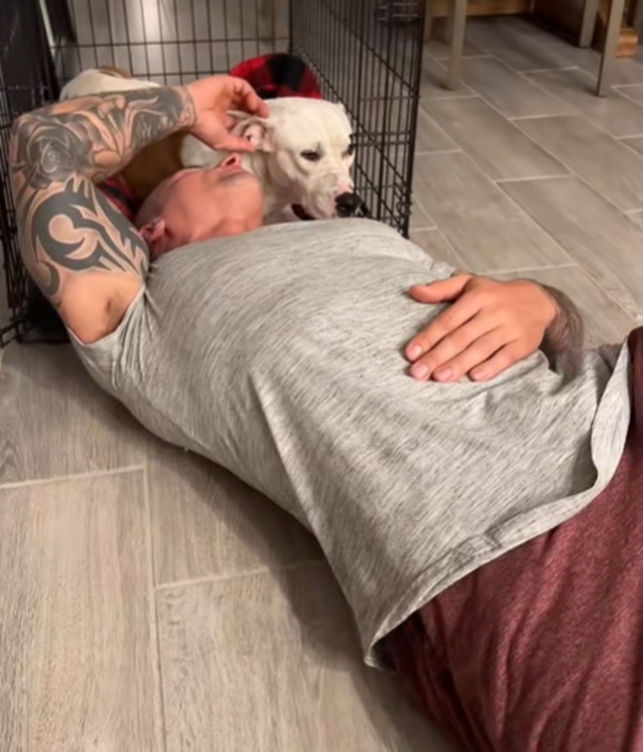 man cuddling with a dog