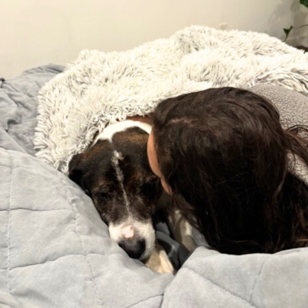 woman and dog laying together
