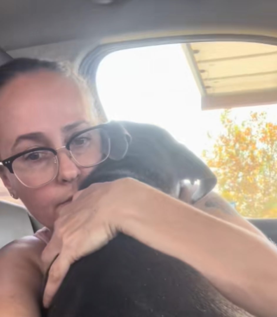 woman hugging a dog in car