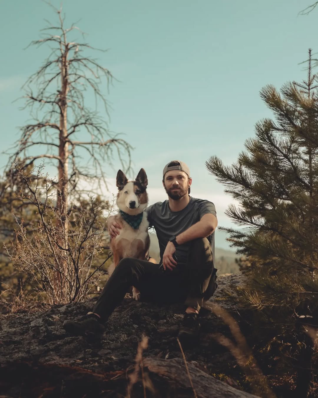 dog and owner sitting in forest