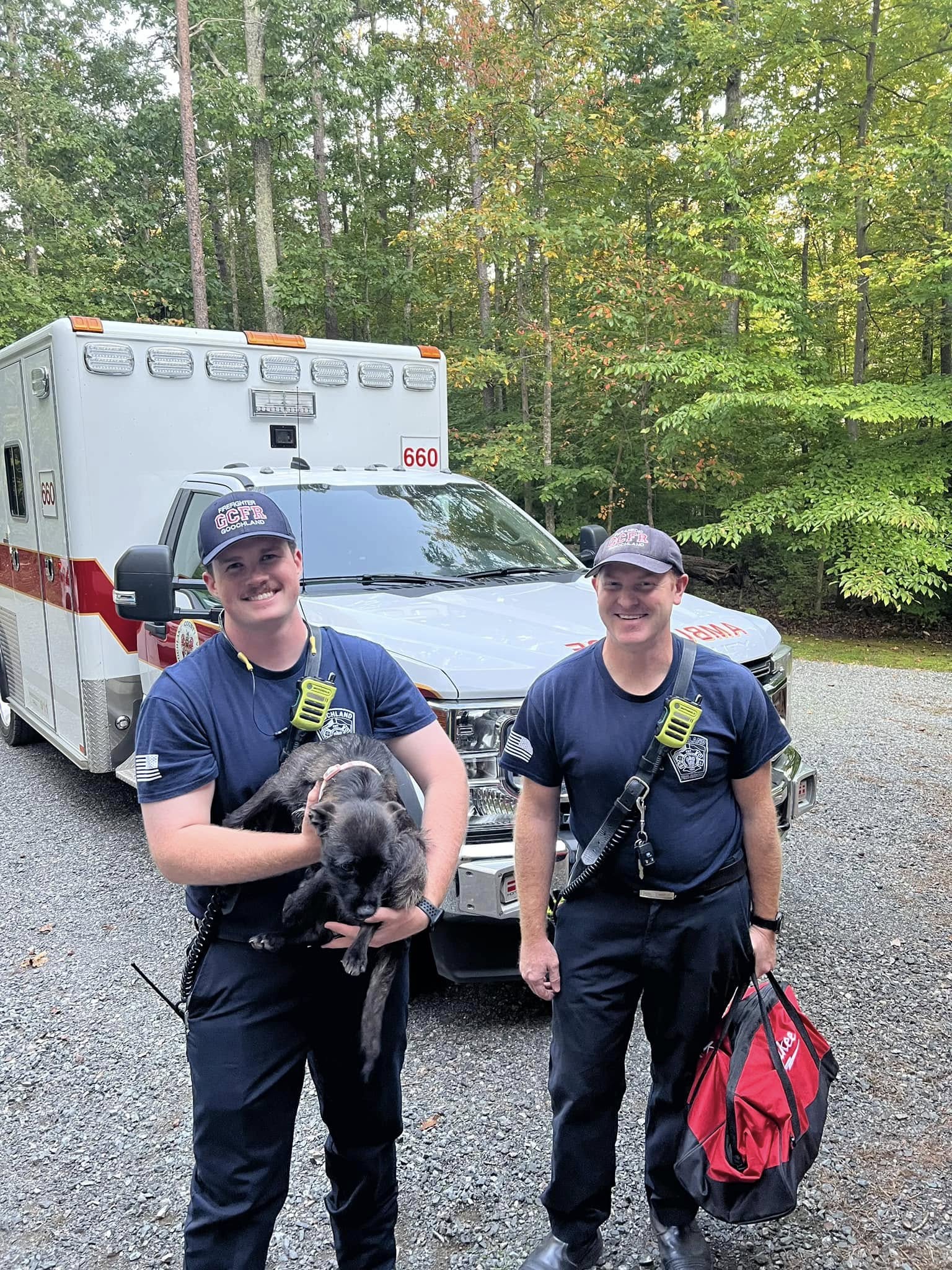 firefighters holding a dog