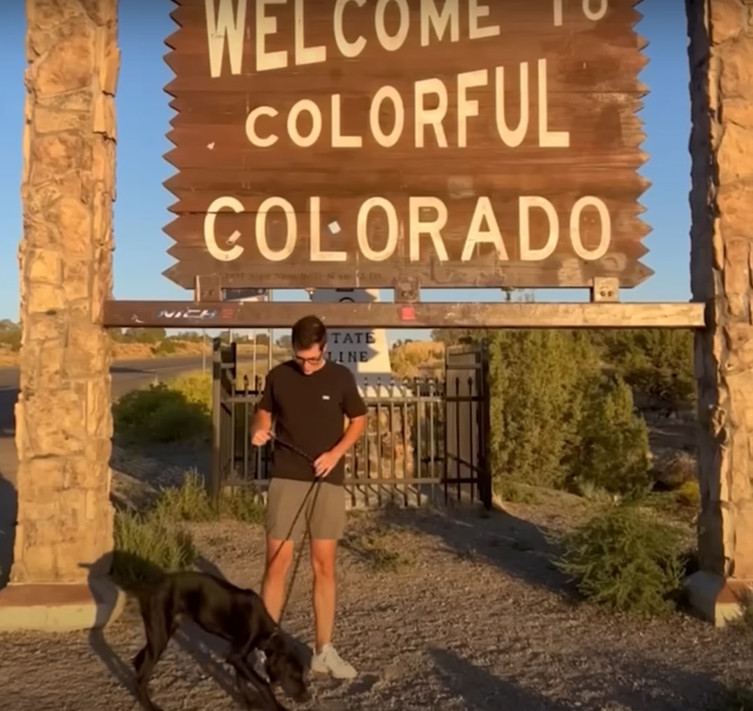 man and black dog on leash