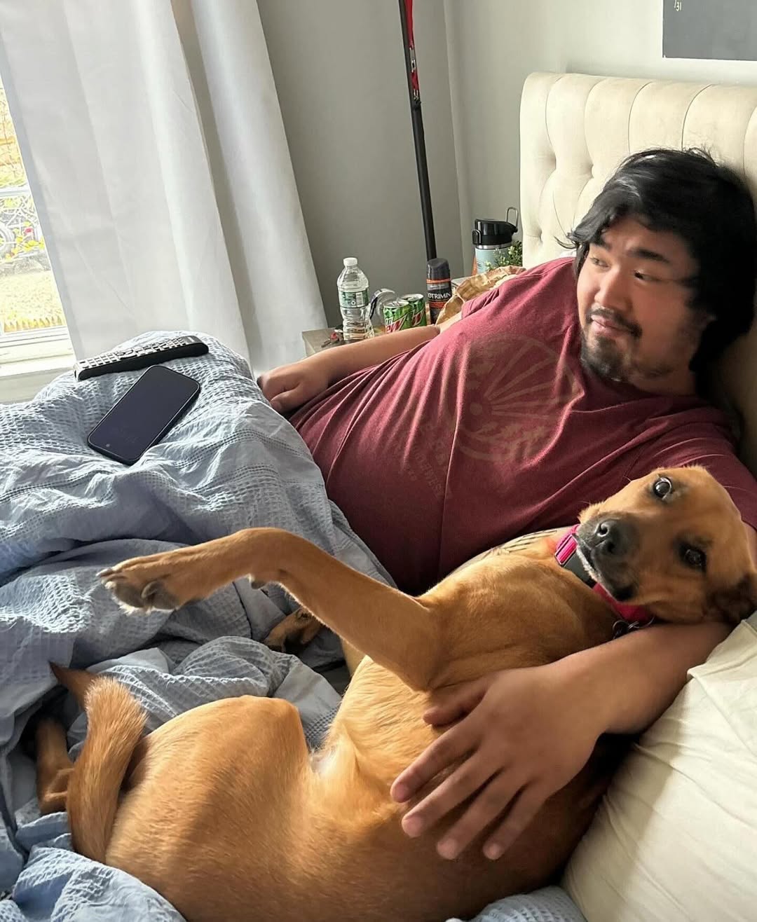 man and dog in bed