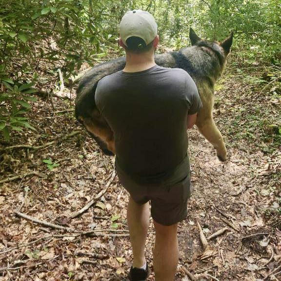 man carrying a big dog