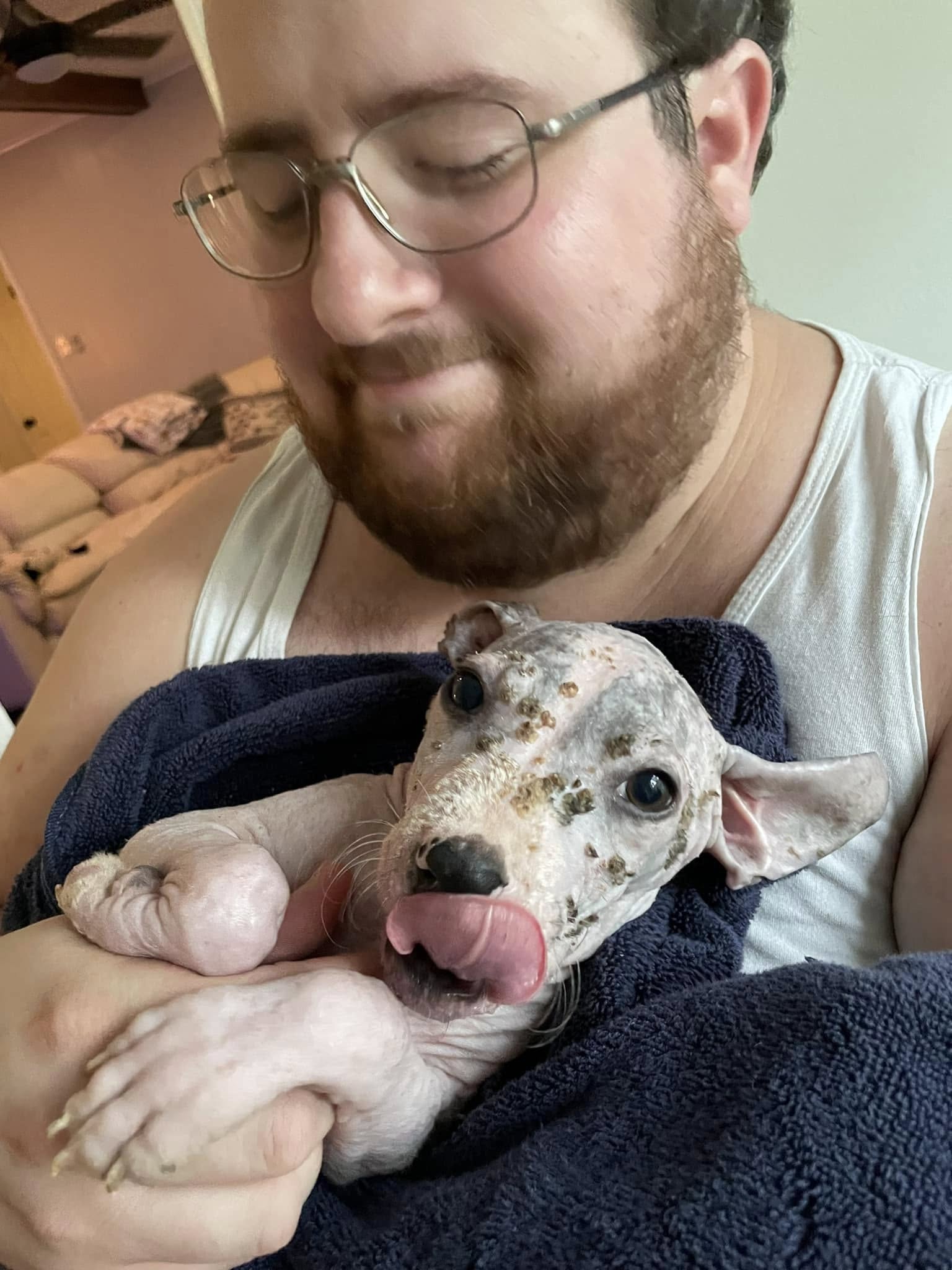 man holding a sick puppy