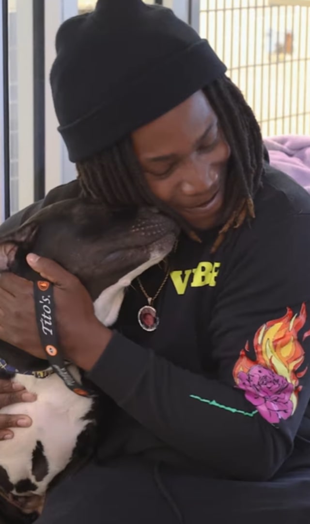 man hugging a black dog