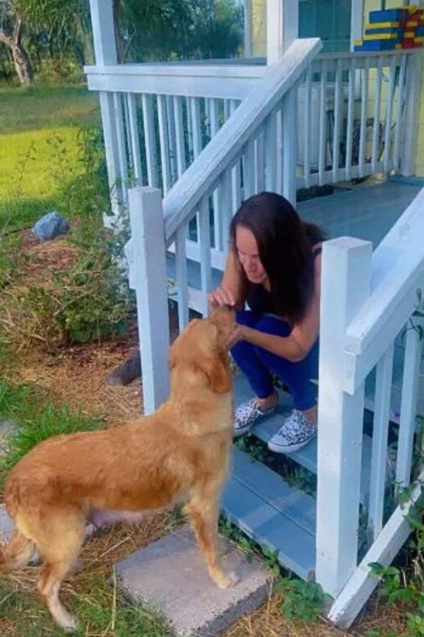 woman and brown dog on porch