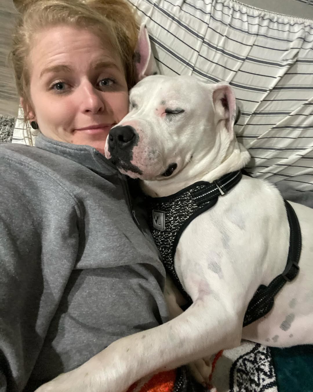 woman and white dog laying together