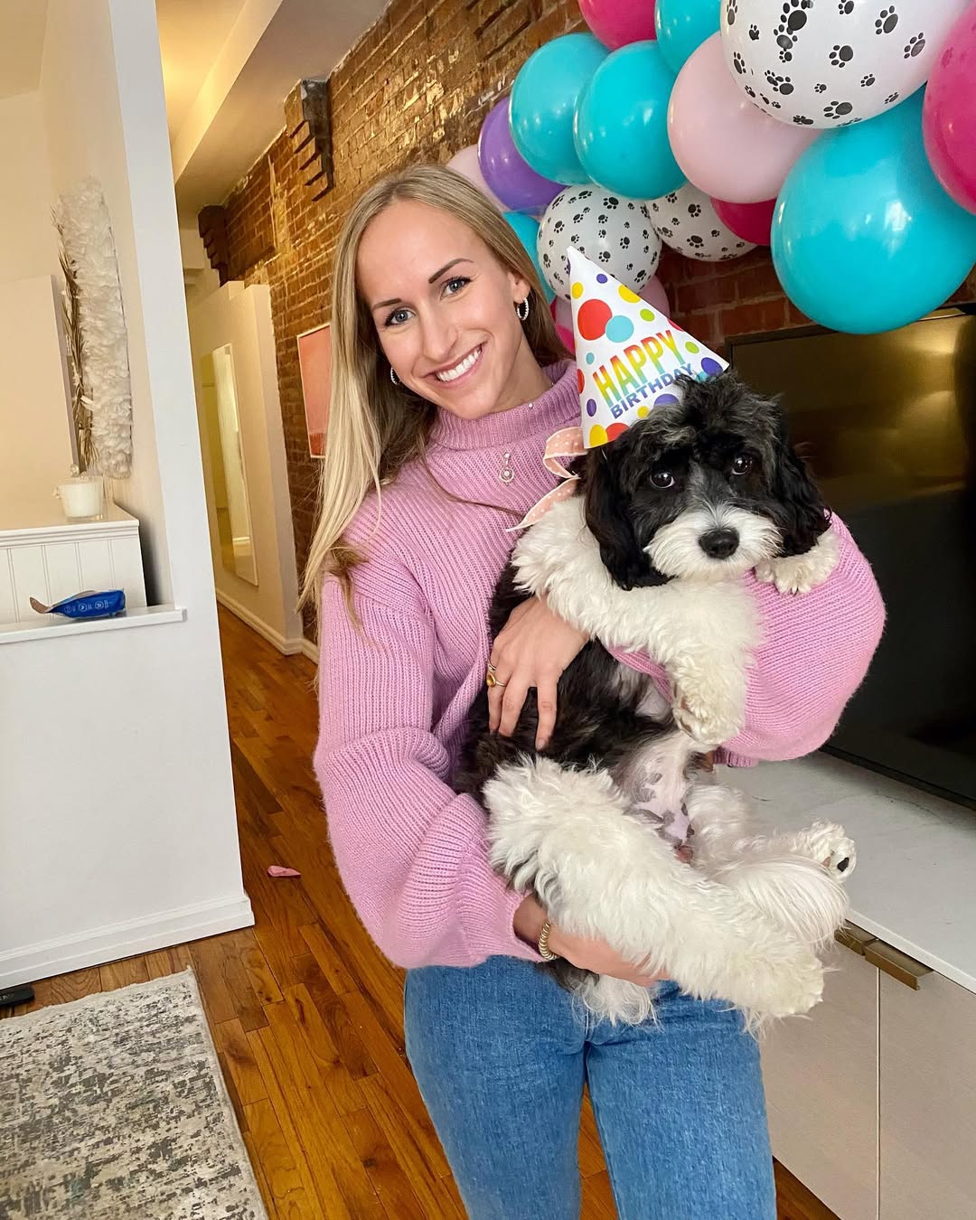 woman holding a black and white dog