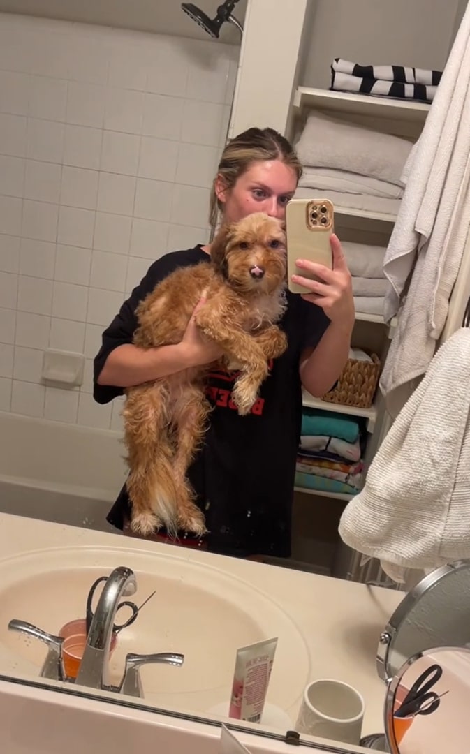 woman holding a dog in bathroom