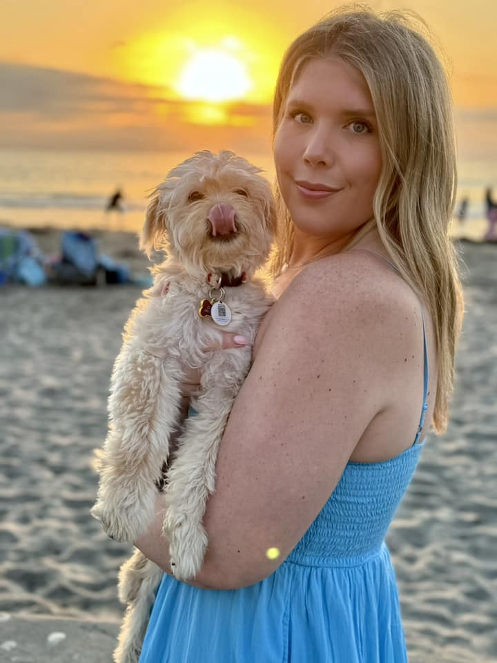 woman holding a white puppy