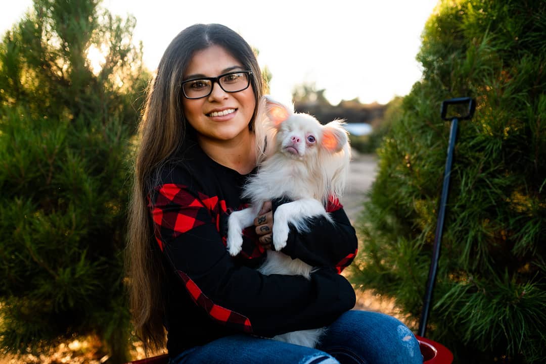 woman holding an albino dog