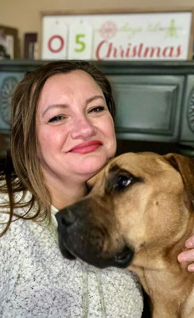 woman hugging brown dog