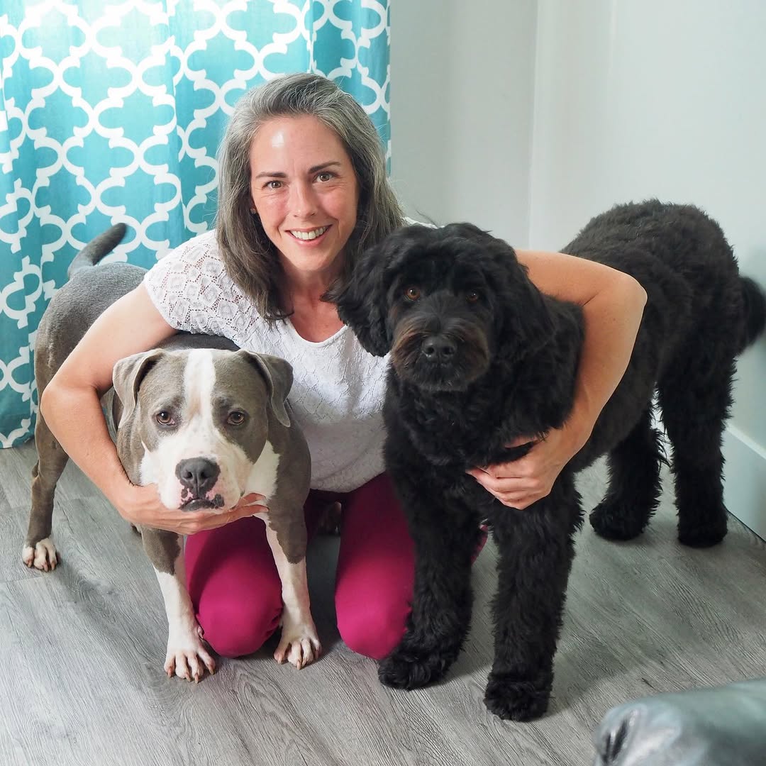 woman hugging two dogs 