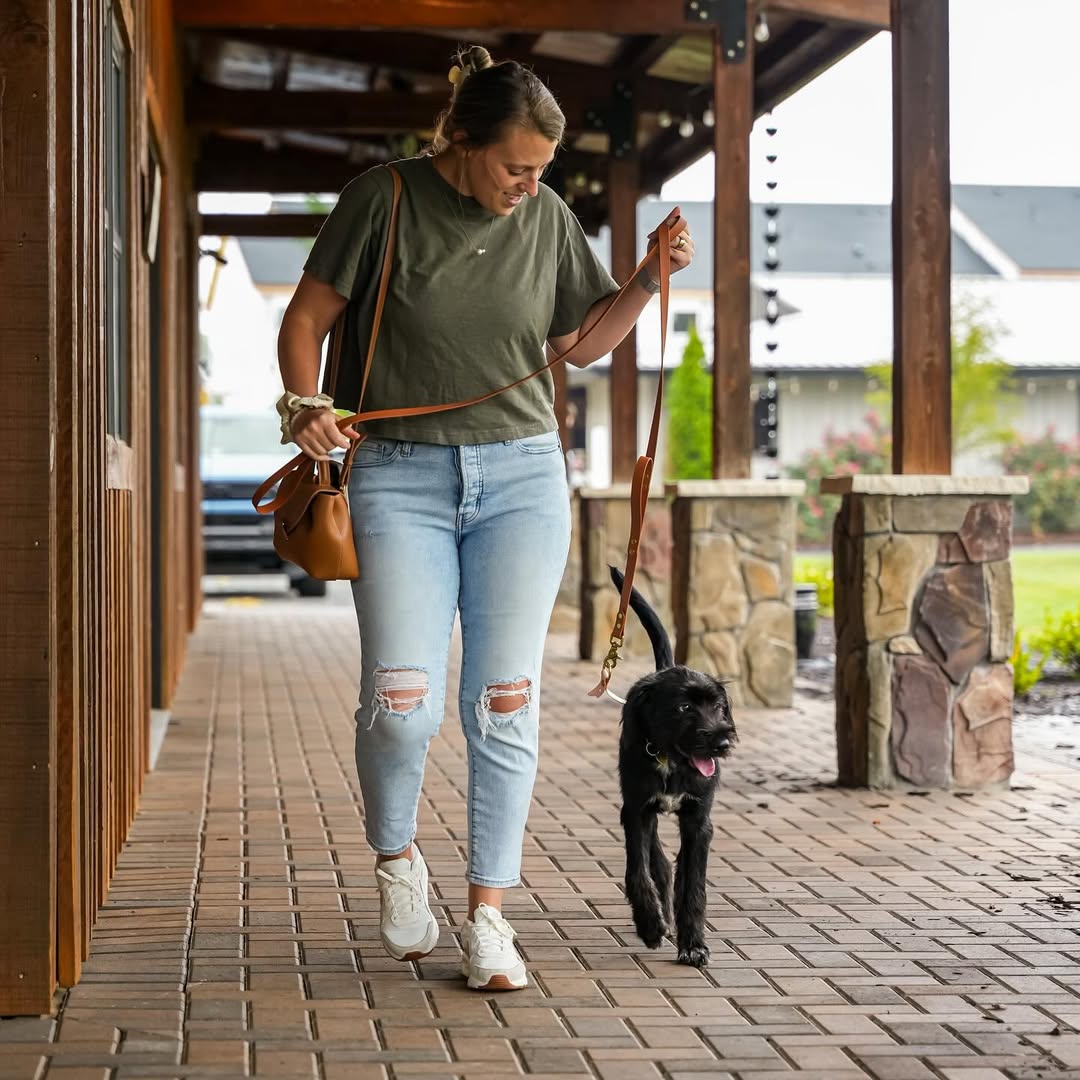 woman walking a black dog