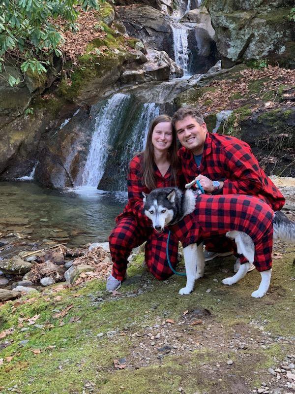couple and husky in matching outfits