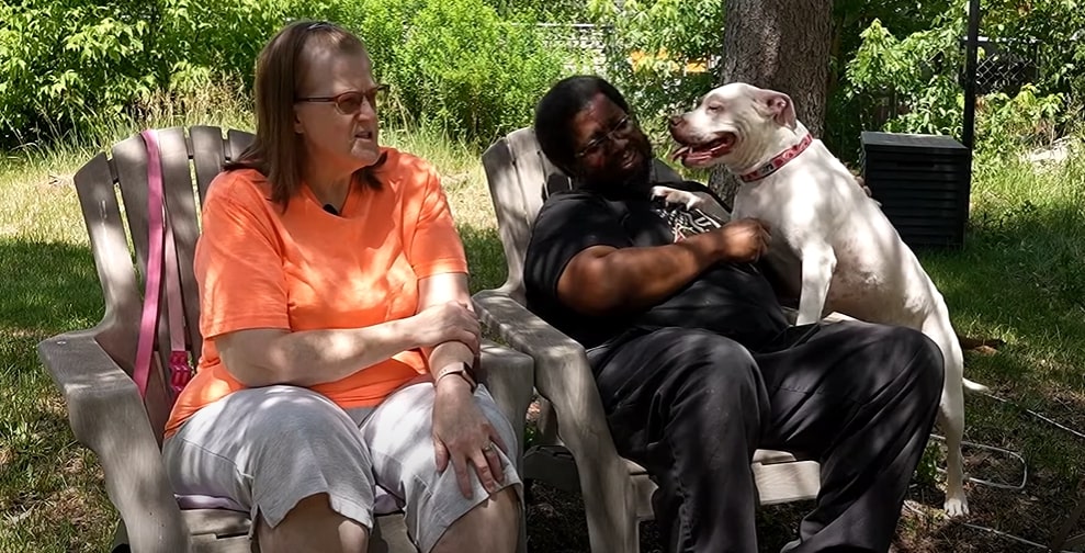couple sitting on sofa and dog