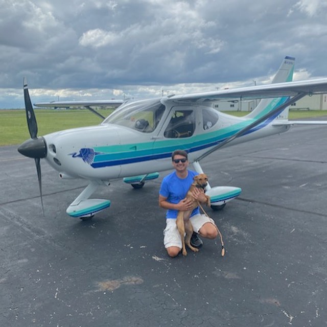 man and dog near airplane