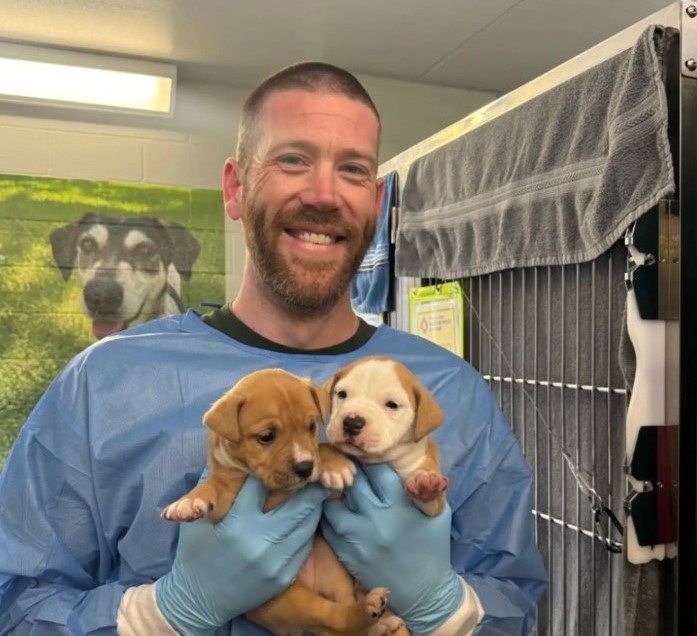man and two puppies