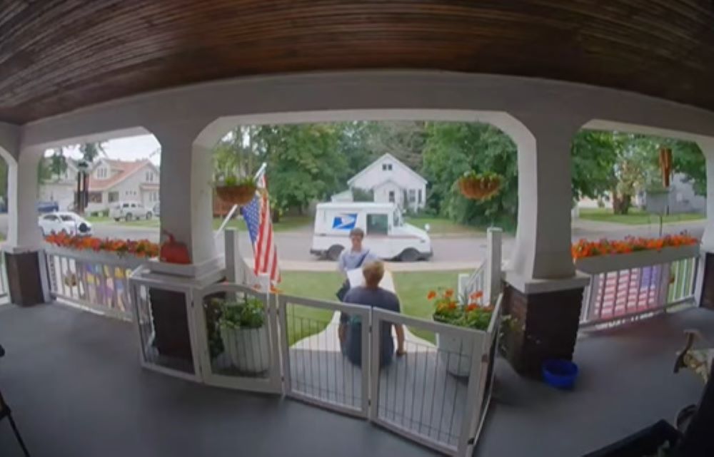 woman and mailman on porch