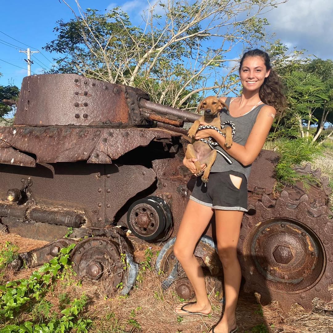 woman holding a dog and posing for picture