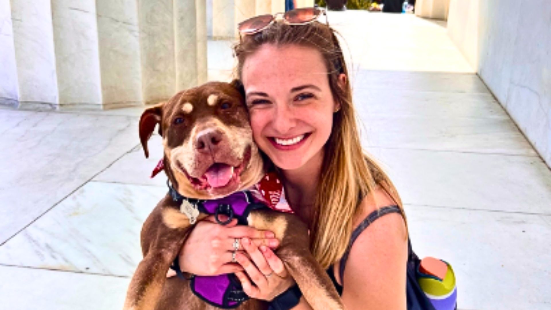 woman hugging a brown dog