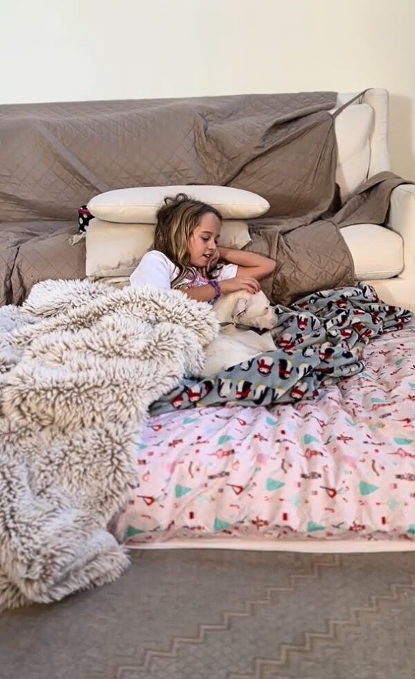 little girl and dog in bed