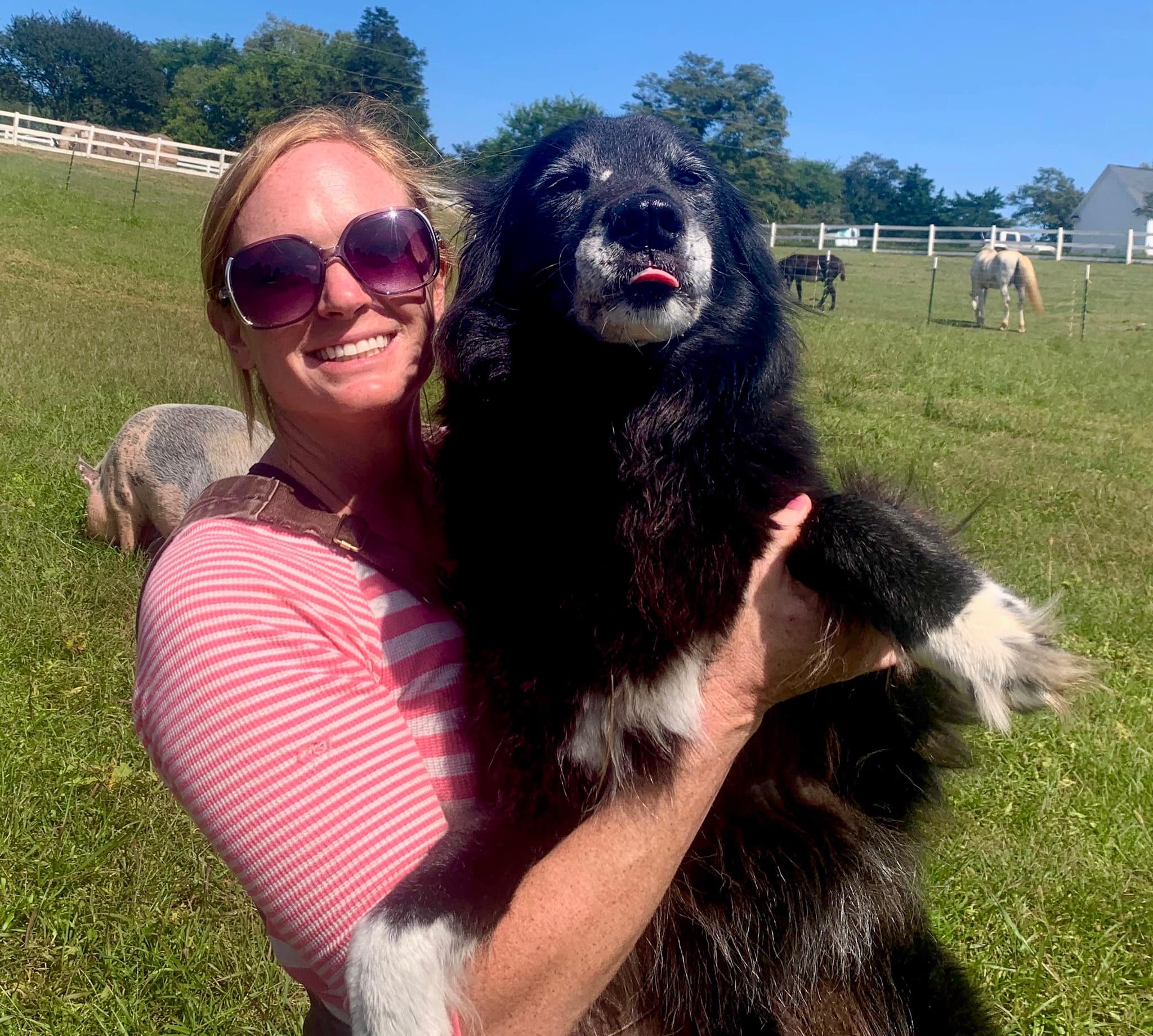 woman holding a black dog