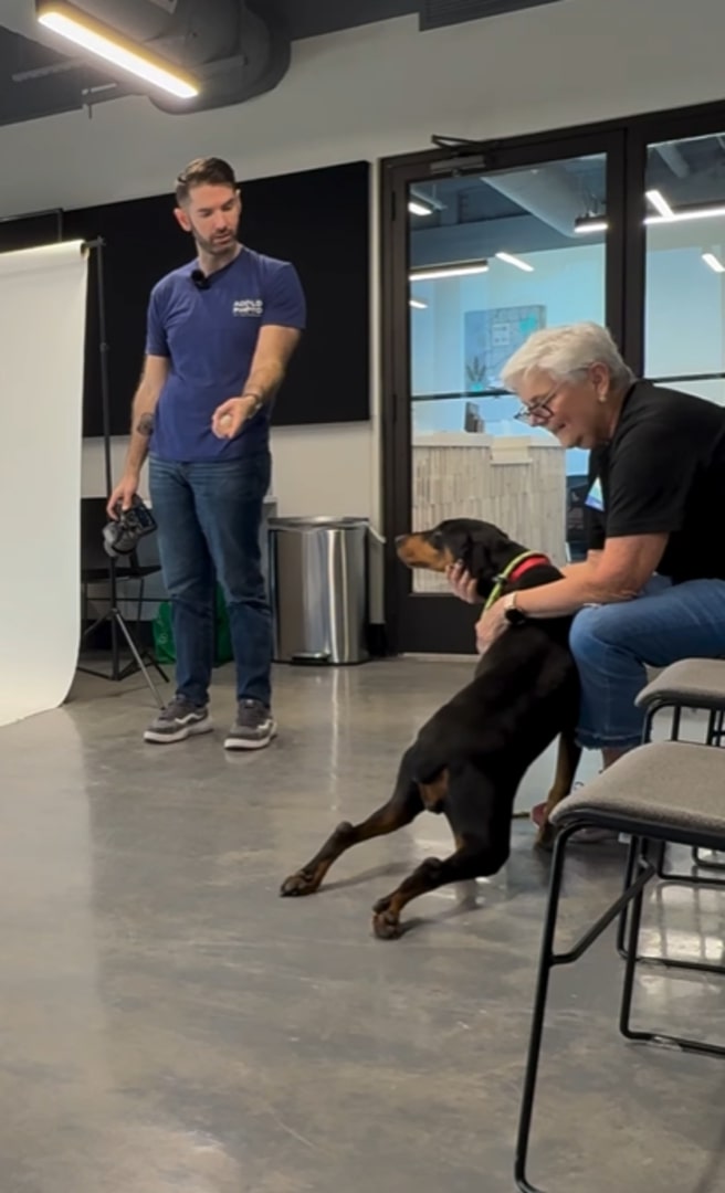 A man trains a dog that is with a woman