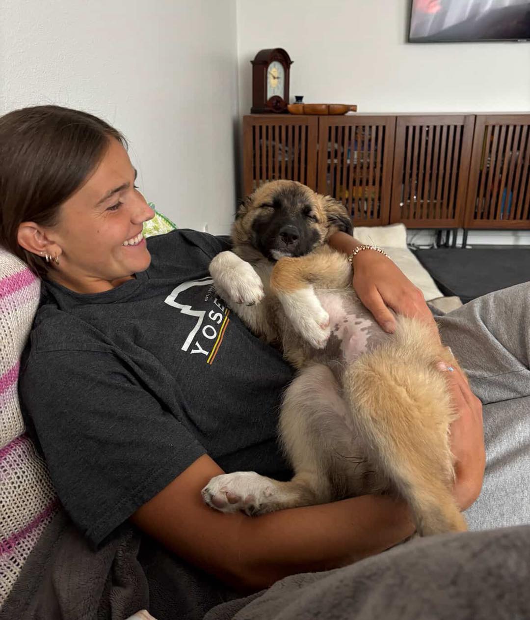 The dog is sleeping in the woman's arms
