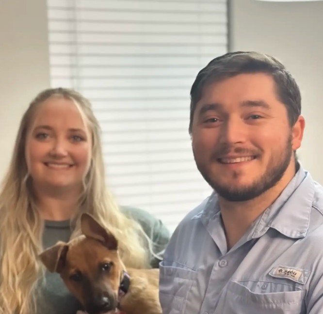 couple and tiny brown dog
