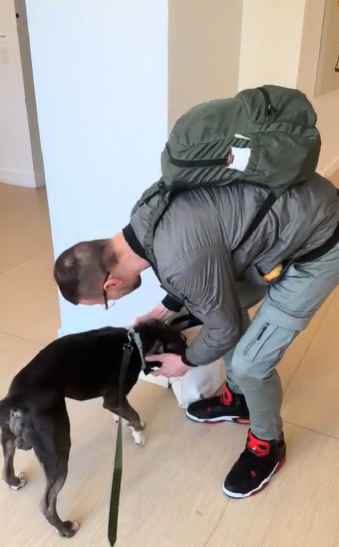 man petting a black dog