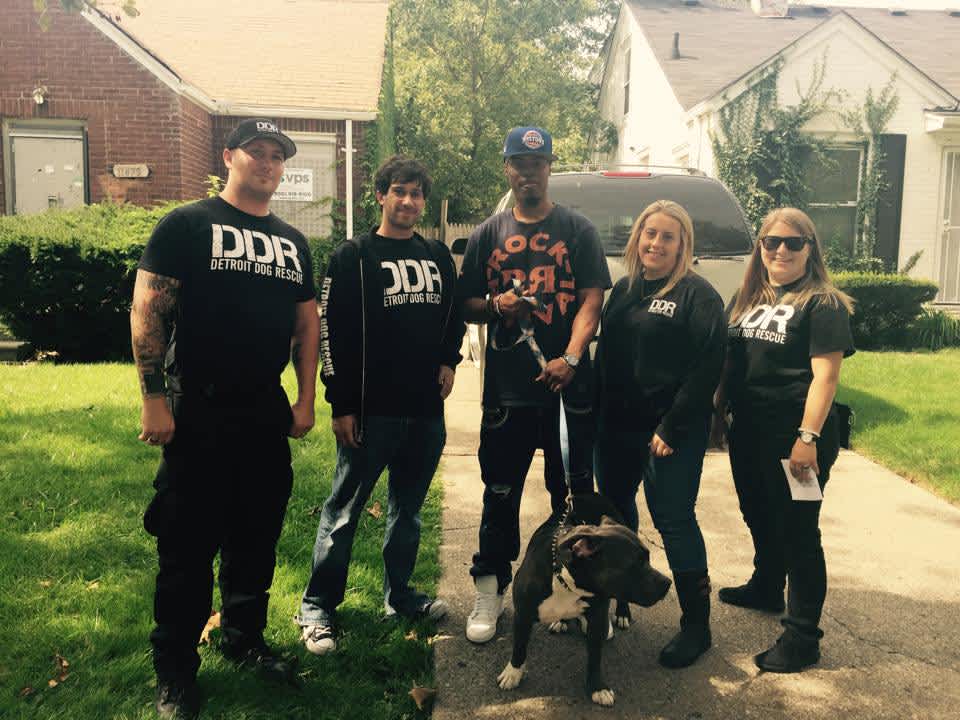 three men two women with a pit bull