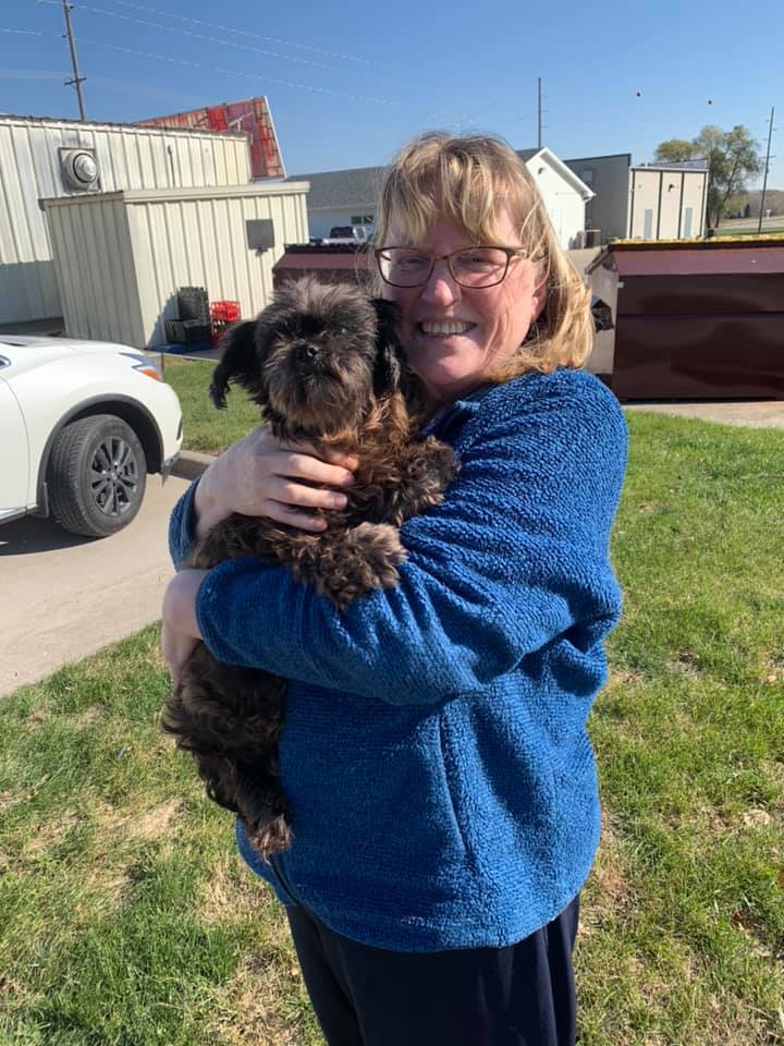 woman holding a black puppy