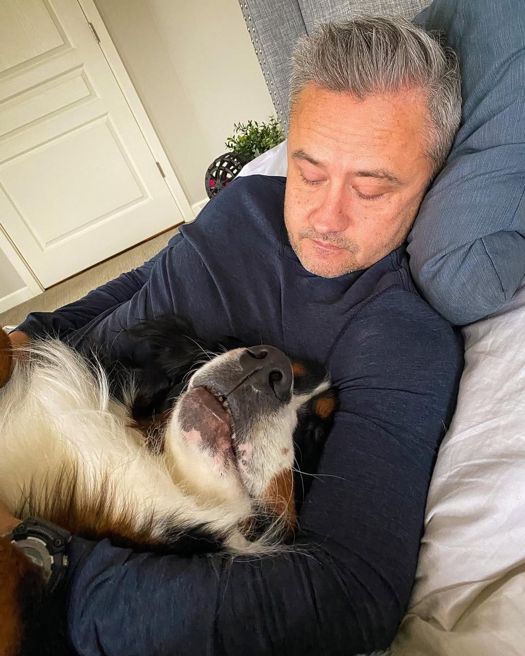 man and dog in bed