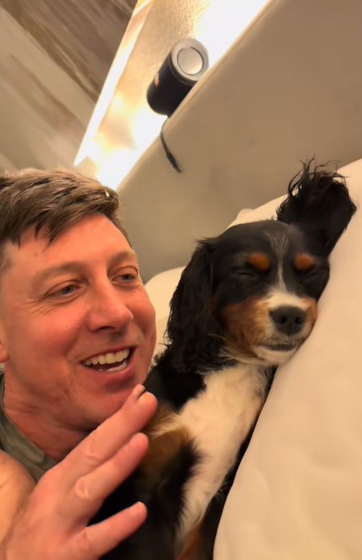 man and tiny black dog