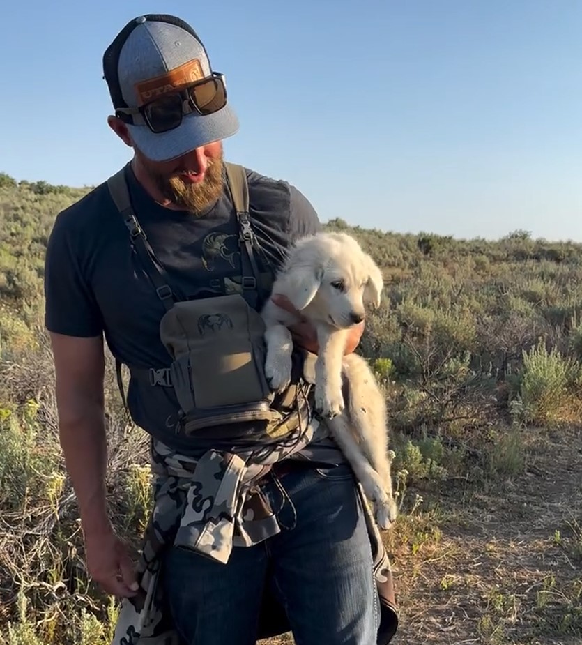 man holding a white puppy
