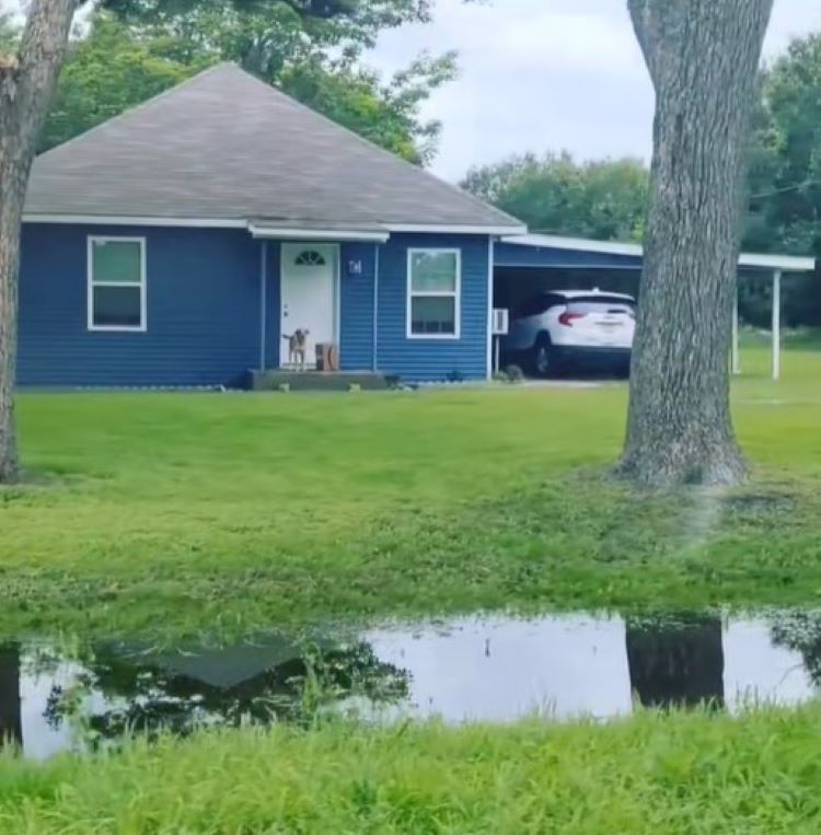 man in front of blue house